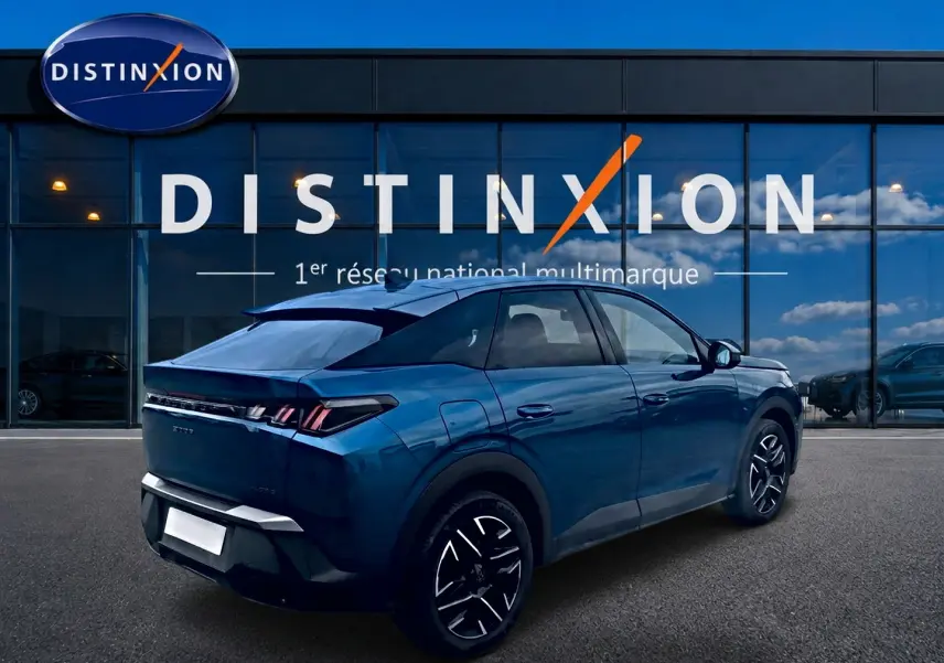 Vue 3/4 arrière droite d'un Peugeot 3008 bleu 2025 avec jantes alu et feux arrière LED, devant une vitrine Distinxion.