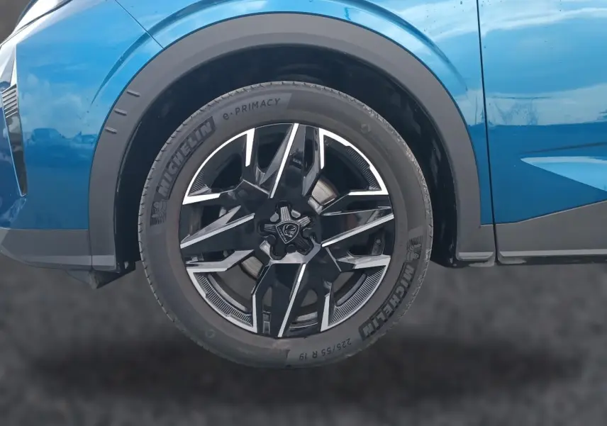 Gros plan sur la roue avant droite du Peugeot 3008 bleu 2025 avec jante alu noire et argentée.