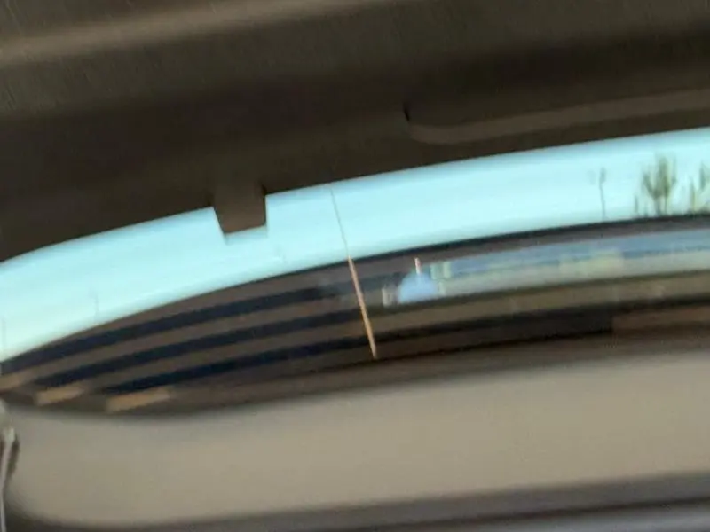 Vue partielle du toit ouvrant panoramique du Citroën C5 Aircross noir Perla Nera avec ciel bleu en arrière-plan.