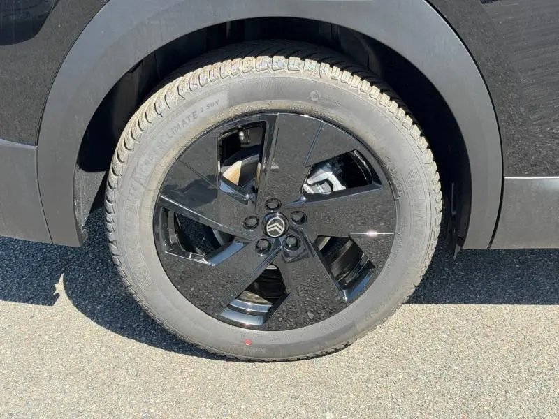 Gros plan sur la roue avant droite noire brillante du Citroën C5 Aircross 1.2 Hybride 145ch 2026 en Noir Perla Nera.