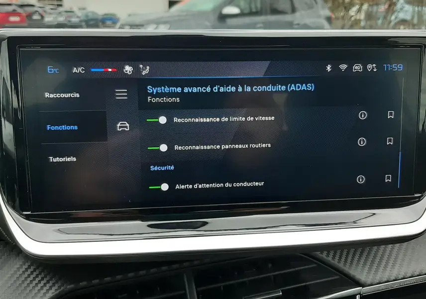 Écran tactile central du tableau de bord de la Peugeot 208 2024 affichant les aides à la conduite, avec finition gris sélénium visible.
