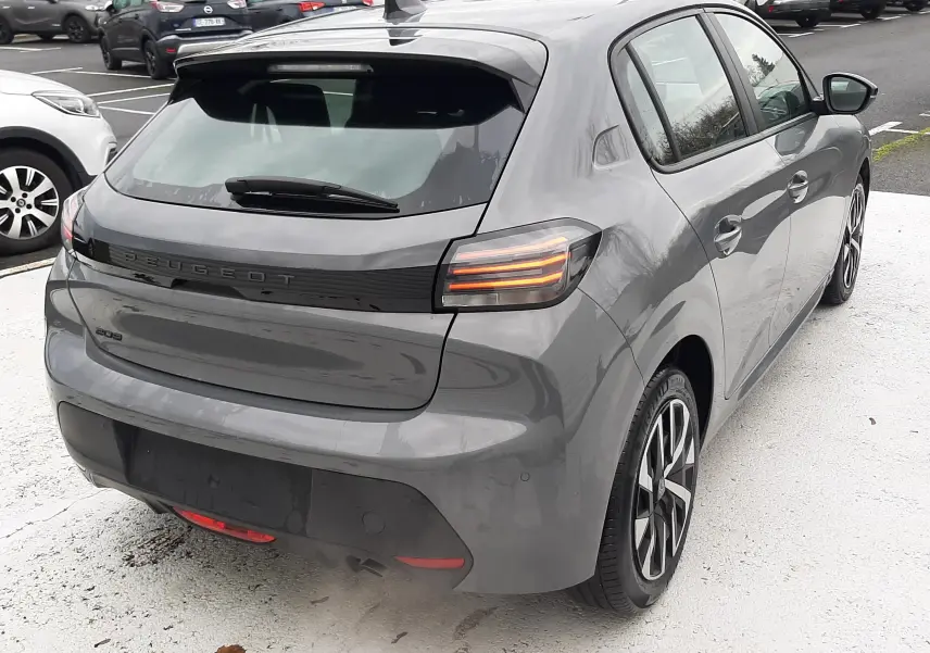 Vue 3/4 arrière droite d'une Peugeot 208 gris selenium 2024 avec feux arrière LED et jantes alliage distinctives.