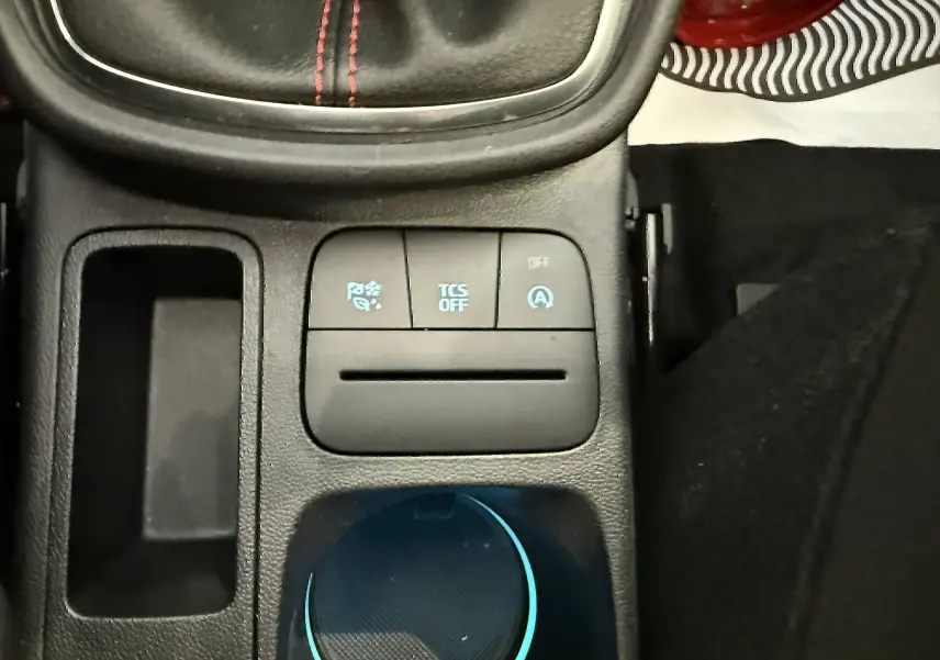 Gros plan sur la console centrale du Ford Puma 2022, montrant les boutons de contrôle et le levier de vitesse en cuir noir avec surpiqûres rouges.