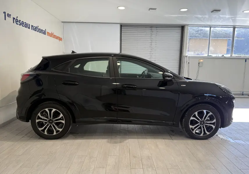 Vue de profil côté gauche d'un Ford Puma noir Agate 2022 avec jantes alliage et finitions ST-Line visibles.