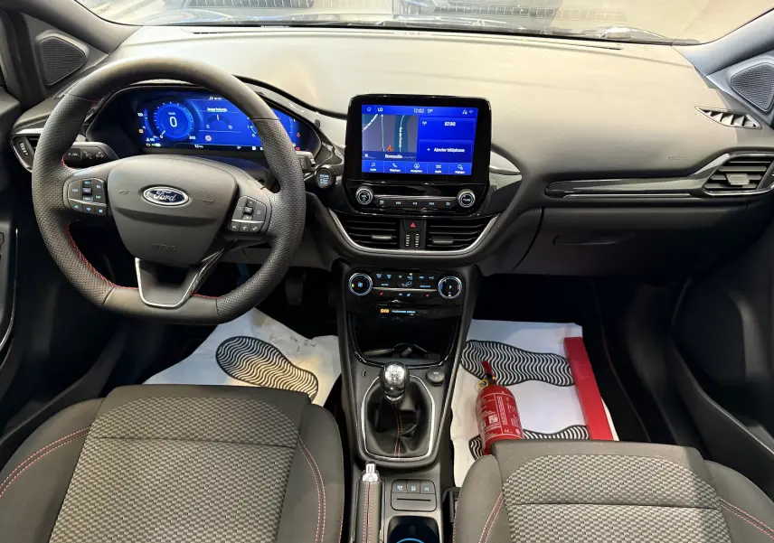 Vue intérieure avant du Ford Puma noir agate 2022, avec tableau de bord numérique et écran central tactile.