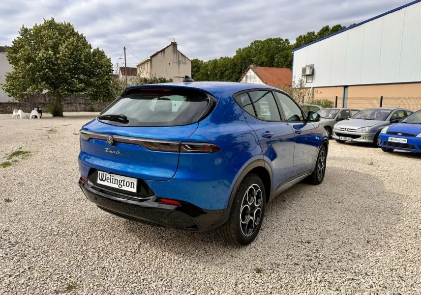 Vue 3/4 arrière droite d'une Alfa Romeo Tonale bleu métallisé avec feux arrière LED et jantes distinctives.
