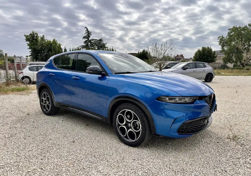 Alfa Romeo Tonale bleu métallisé vue 3/4 avant droit, avec jantes distinctives et calandre caractéristique.