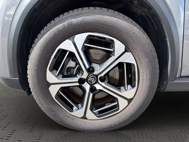 Gros plan sur la roue avant gauche de la Citroën C3 Aircross Electric gris mercury avec jante alliage 17 pouces au design moderne.
