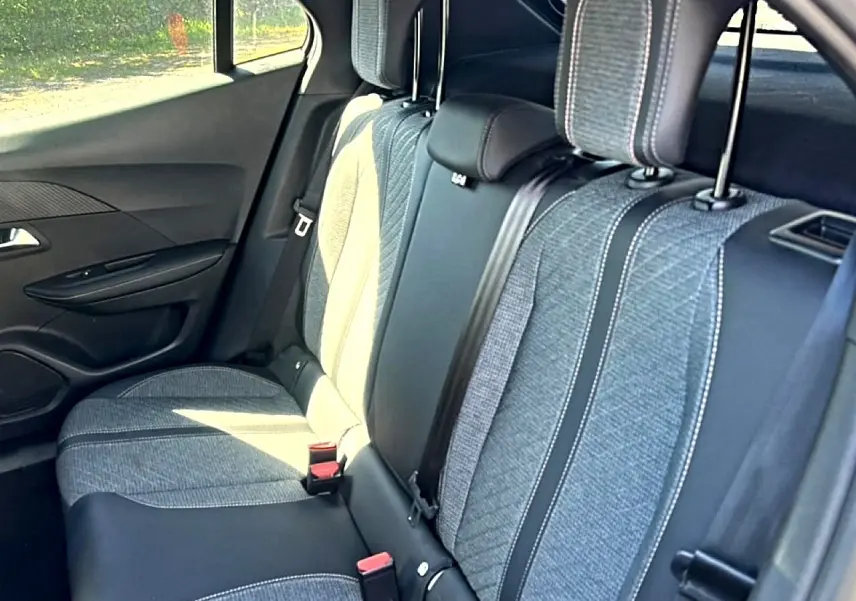 Vue intérieure côté droit sur la banquette arrière gris clair et tissu embossé du Peugeot 2008 1.2 100 allure 2025.