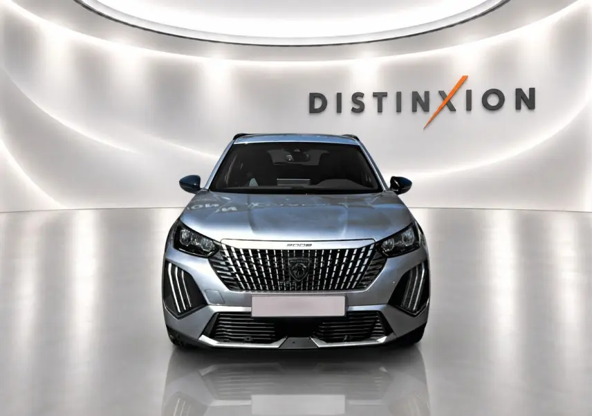 Peugeot 2008 gris Artense vue de face dans un studio avec calandre verticale et signature lumineuse LED distinctive.