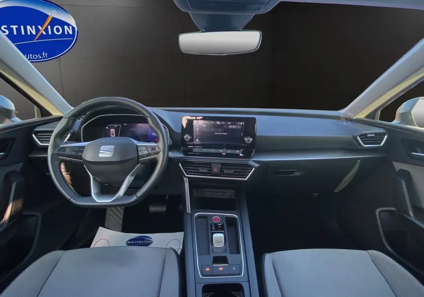 Vue intérieure frontale du tableau de bord et volant cuir multifonctions de la SEAT Leon IV gris Magnetic 2024.