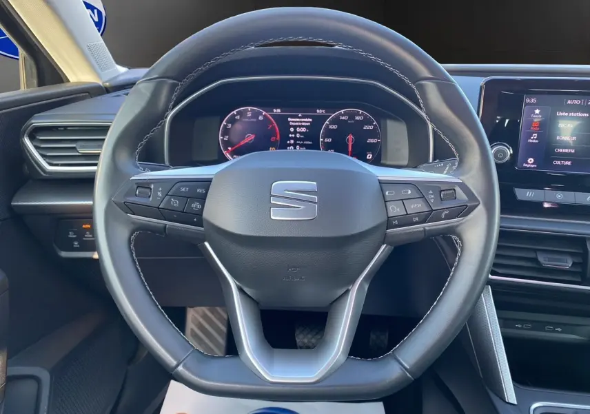 Vue rapprochée du volant cuir multifonctions et tableau de bord numérique du SEAT Leon IV 2024 finition Edition Vision.