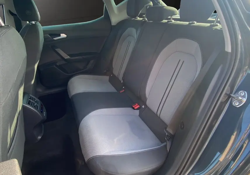 Vue intérieure côté droit sur les sièges arrière en tissu noir et gris d'une SEAT LEON IV 2024 avec portière ouverte.