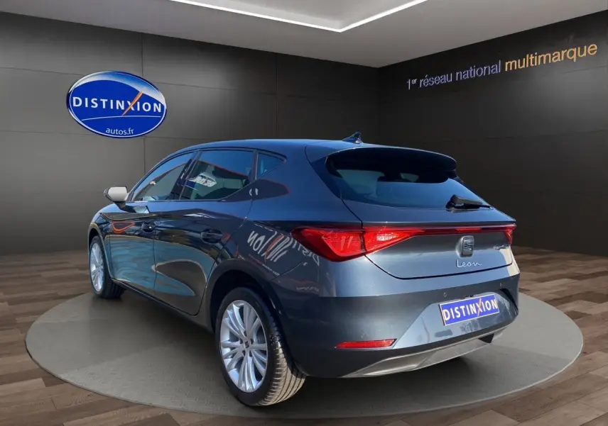 Vue 3/4 arrière droite d'une SEAT Leon gris magnetic 2024 avec jantes alu 17 pouces et vitres surteintées.