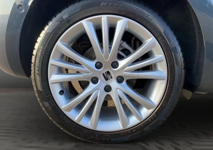 Gros plan sur la jante alu 17 pouces argentée avec logo SEAT, montée sur une SEAT Leon gris magnetic.