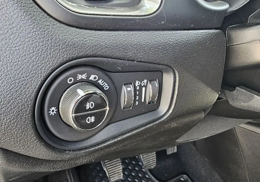 Gros plan sur le bouton de commande des phares et réglages d’éclairage du tableau de bord du Jeep Renegade Sting Gray 2020.