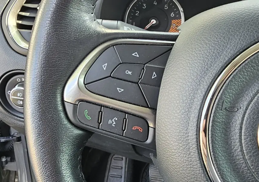 Gros plan sur le volant en cuir noir du Jeep Renegade 2020, avec commandes intégrées et logo central chromé.