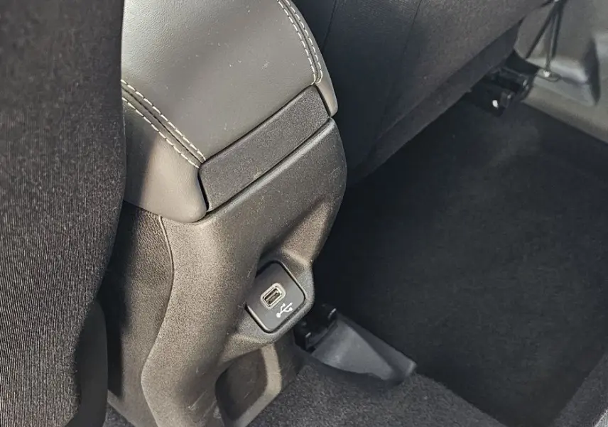 Détail de la prise USB située sous le siège avant dans l'habitacle tissu noir du Jeep Renegade Sting Gray 2020.