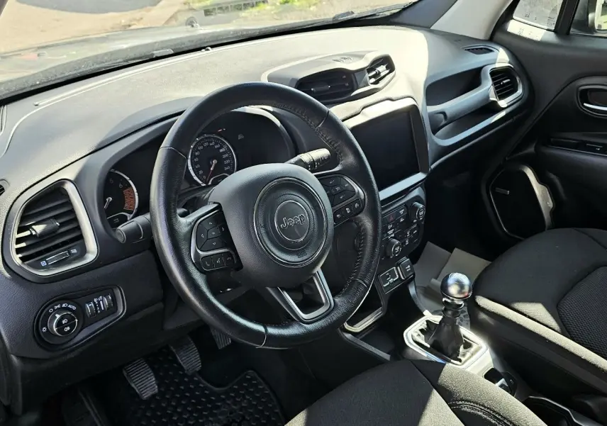 Intérieur du Jeep Renegade 2020 avec volant cuir, tableau de bord noir et levier de vitesse manuel visible côté conducteur.