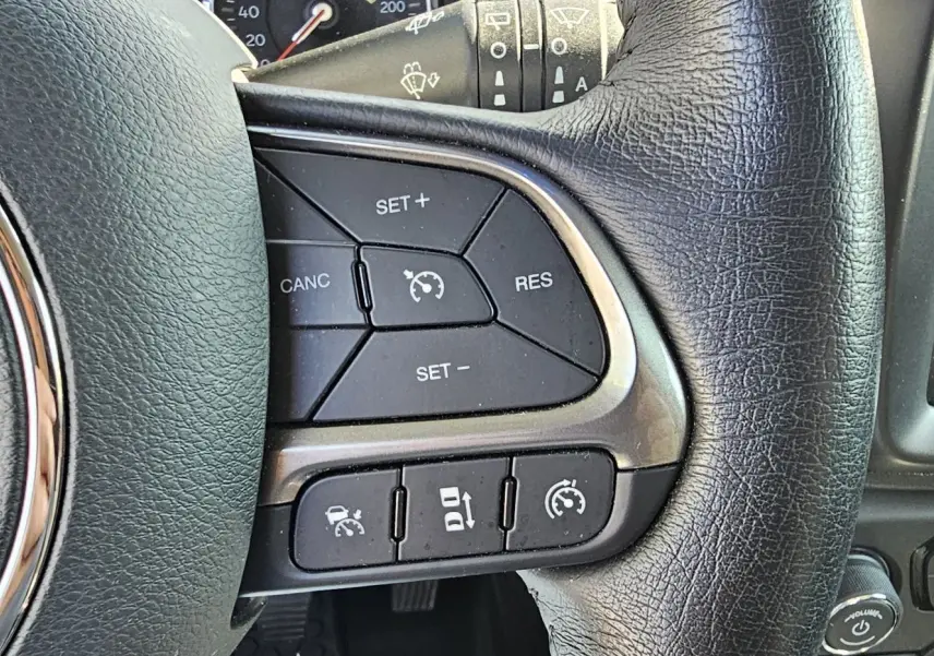 Gros plan sur les commandes de régulateur de vitesse au volant cuir noir du Jeep Renegade Sting Gray 2020.