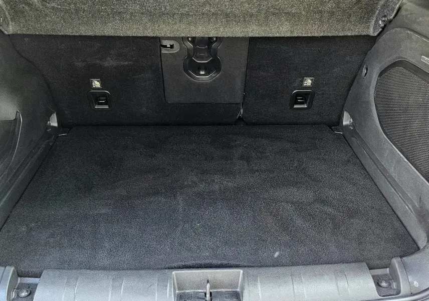 Coffre spacieux et propre du Jeep Renegade Sting Gray 2020, avec revêtement noir et rangements latéraux intégrés.