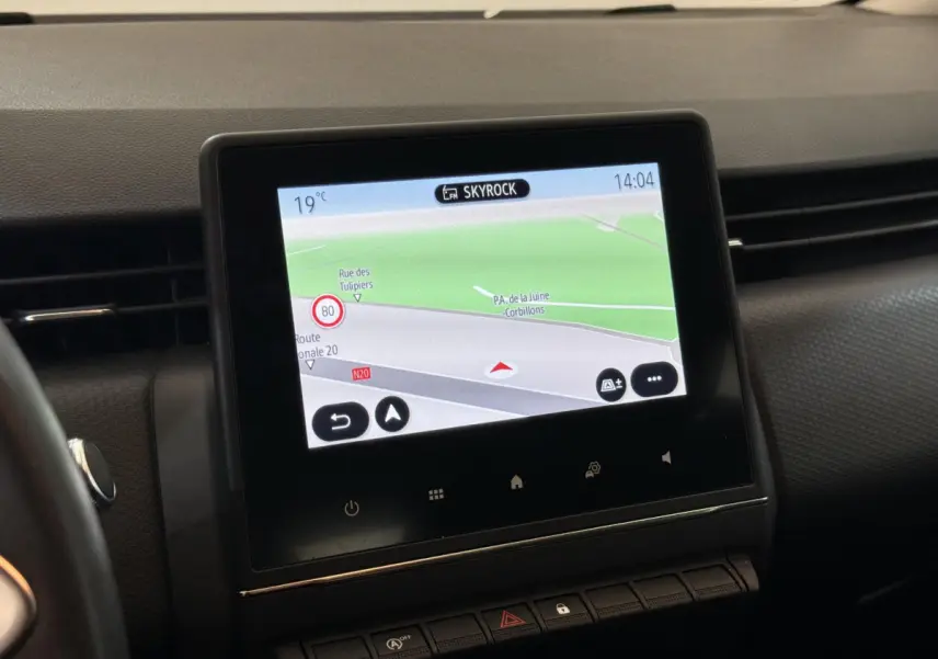 Écran tactile central affichant la navigation dans l'habitacle noir de la Renault Clio Business blanche, vue de face.