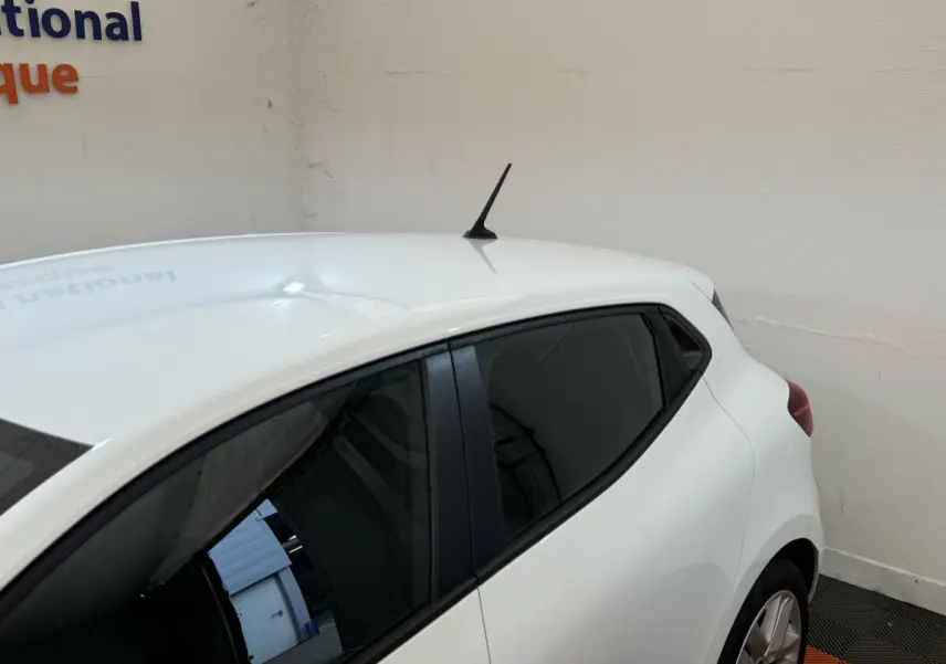 Vue arrière côté droit d'une Renault Clio Business blanche avec vitres teintées et antenne sur le toit.