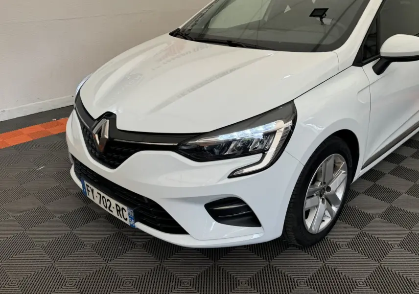 Vue 3/4 avant droit d'une Renault Clio Business blanche avec phares LED et jantes alliage visibles.