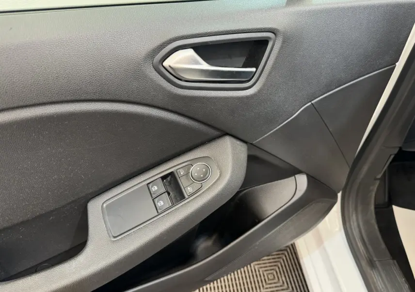 Gros plan sur la porte avant gauche noire d'une Renault Clio blanche, avec commandes des vitres et rétroviseurs.