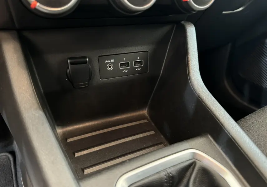 Gros plan sur la console centrale noire de la Renault Clio Business avec ports USB et prise Aux-In visibles.