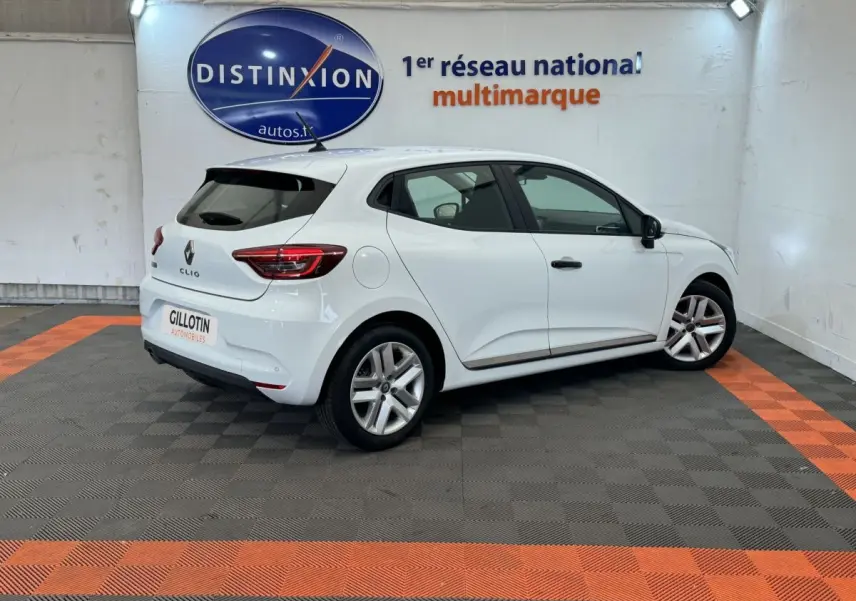 Renault Clio Business blanche vue de trois quarts arrière droit, dans un showroom avec logo Distinxion en arrière-plan.
