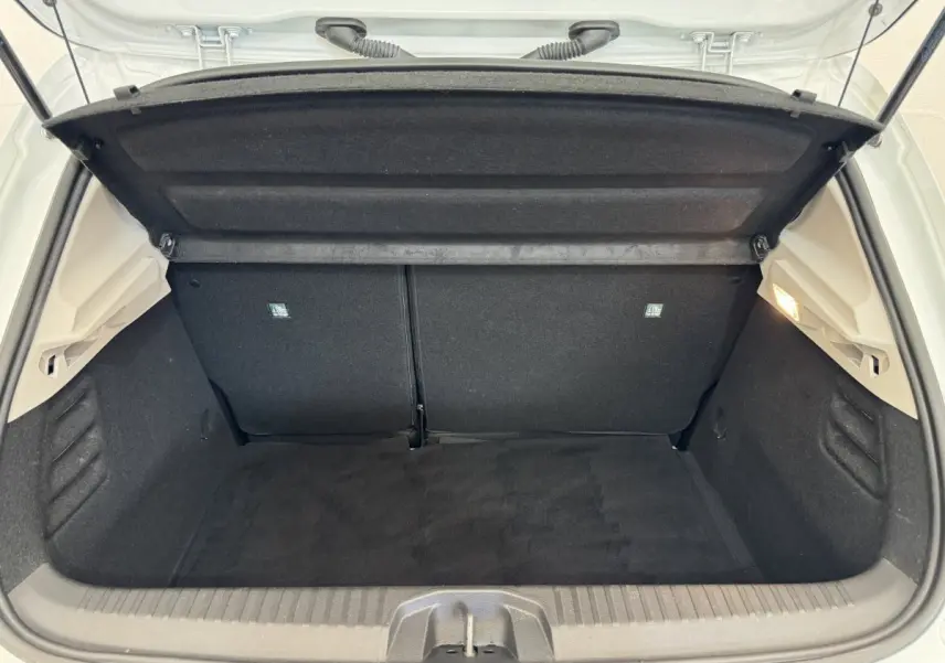 Coffre ouvert de la Renault Clio Business blanche, vue de l'arrière montrant l'espace de chargement vide et propre.