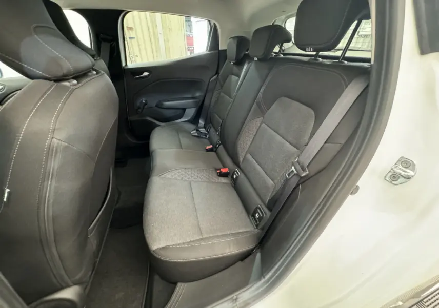 Vue côté gauche des sièges arrière gris foncé de la Renault Clio Business blanche avec porte ouverte.