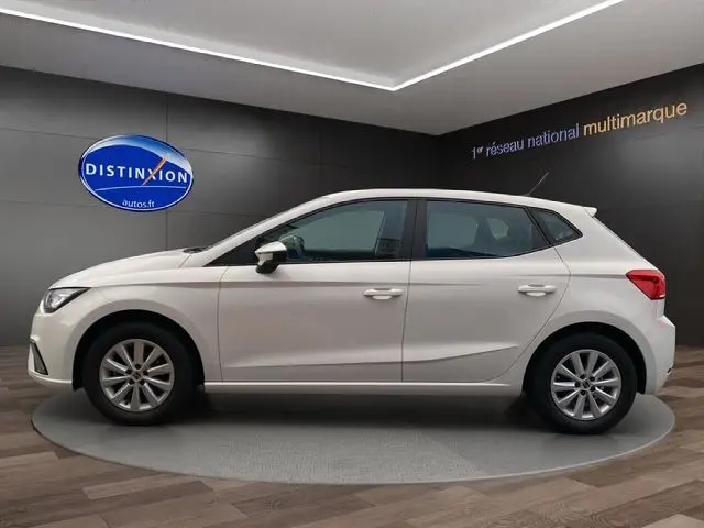 Profil latéral droit d'une SEAT Ibiza blanche Candy 5 portes, finition Style, dans un showroom moderne.