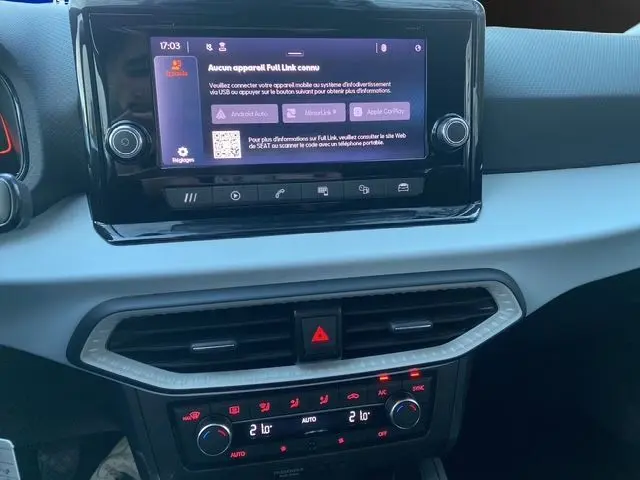 Tableau de bord blanc candy de la SEAT IBIZA 2023 avec écran tactile central et commandes climatisation en vue rapprochée.