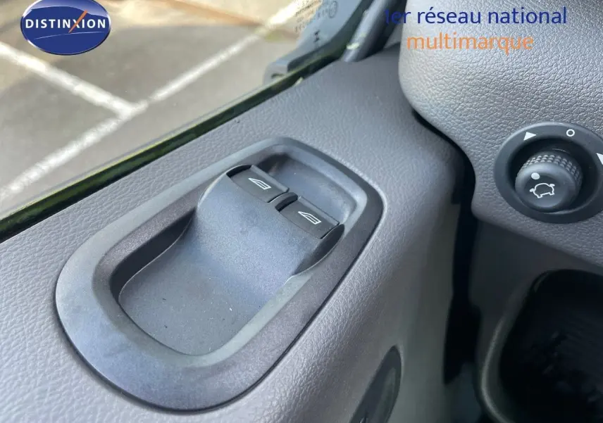 Gros plan sur les commandes des vitres électriques côté gauche du tableau de bord du Ford Transit Fourgon blanc 2023.