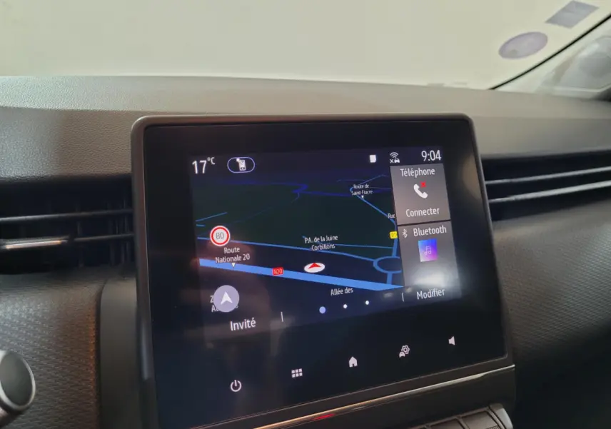 Écran tactile central de navigation et connectivité Bluetooth dans le tableau de bord d'une Renault Clio Business blanche, vue intérieure.