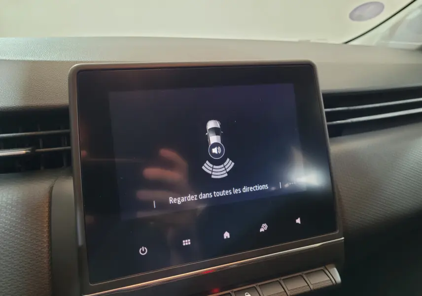 Écran tactile central de la Renault Clio Business blanche 2021 affichant l'alerte de détection d'obstacles.