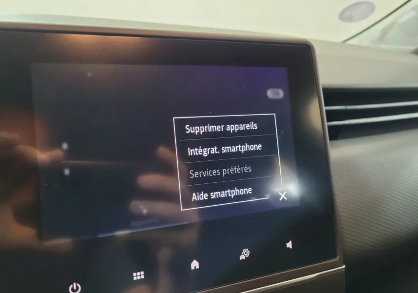 Écran tactile central affichant les options smartphone dans l'habitacle d'une Renault Clio Business blanche de 2021.
