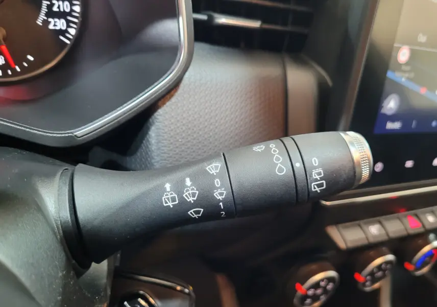 Gros plan sur la commande des essuie-glaces du tableau de bord d'une Renault Clio Business blanche de 2021.