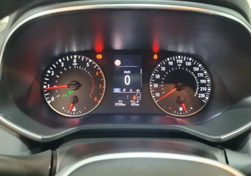 Vue rapprochée du tableau de bord de la Renault Clio Business blanche, affichant le compteur et l'écran digital central.