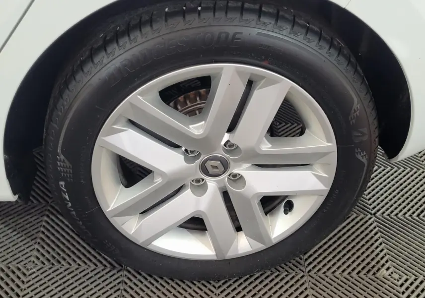 Gros plan sur la roue avant droite blanche d'une Renault Clio Business SCe 65 2021 avec jante alliage argentée.