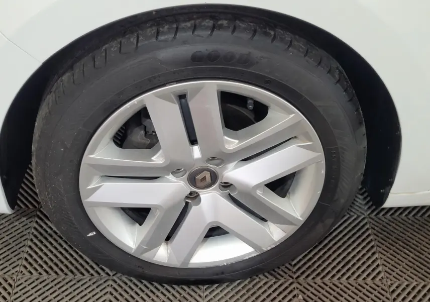 Gros plan sur la roue avant droite d'une Renault Clio Business blanche, avec jante alliage et pneu Goodyear.