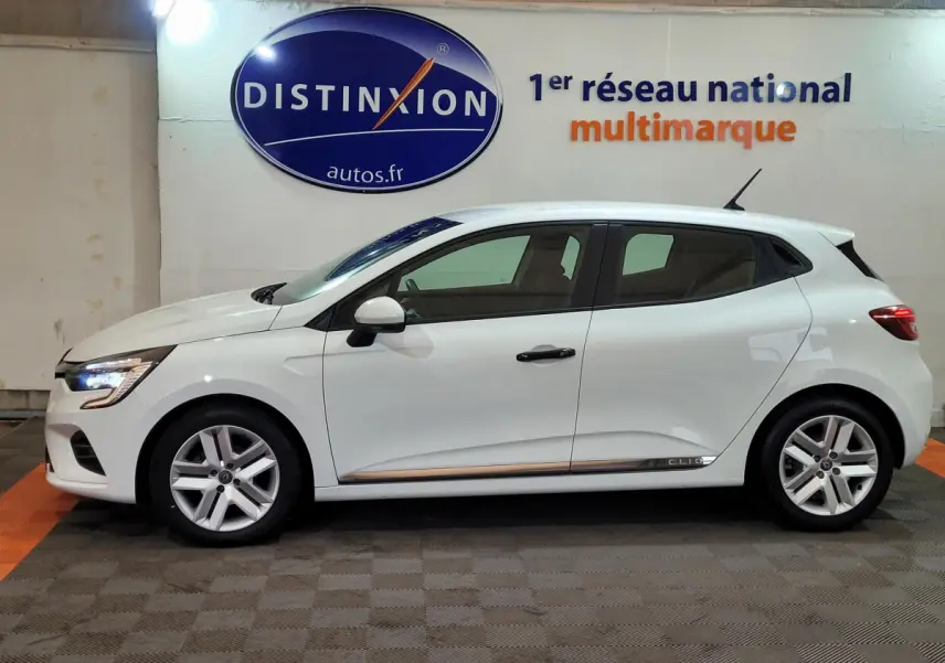 Profil côté gauche d'une Renault Clio Business blanche de 2021, avec jantes alliage et feux LED visibles.
