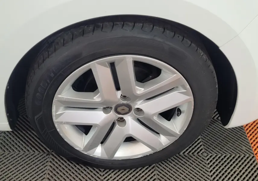 Gros plan sur la roue avant droite blanche d'une Renault Clio Business SCe 65 de 2021 avec jante argentée design moderne.