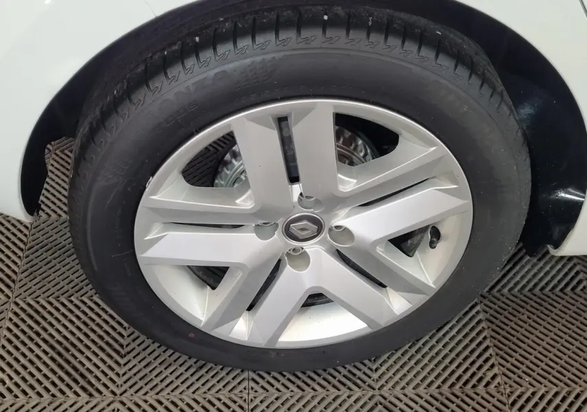 Gros plan sur la roue avant gauche d'une Renault Clio Business blanche, avec passage de roue et partie de la carrosserie visibles.