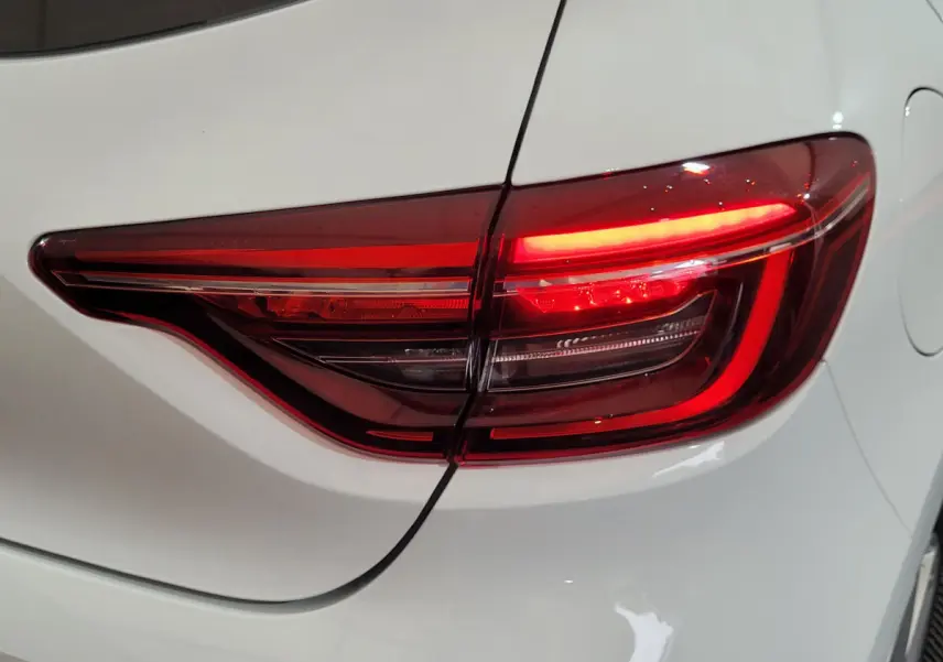 Gros plan sur le feu arrière droit rouge d'une Renault Clio Business blanche de 2021, avec carrosserie lisse.