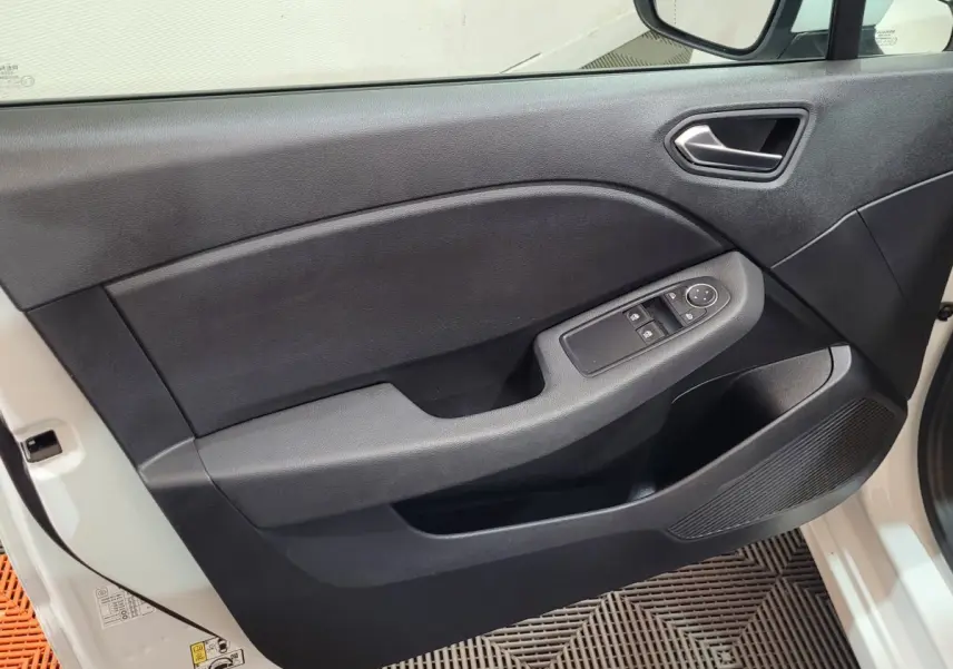 Vue côté gauche de la porte avant noire de la Renault Clio Business blanche avec commandes électriques des vitres.