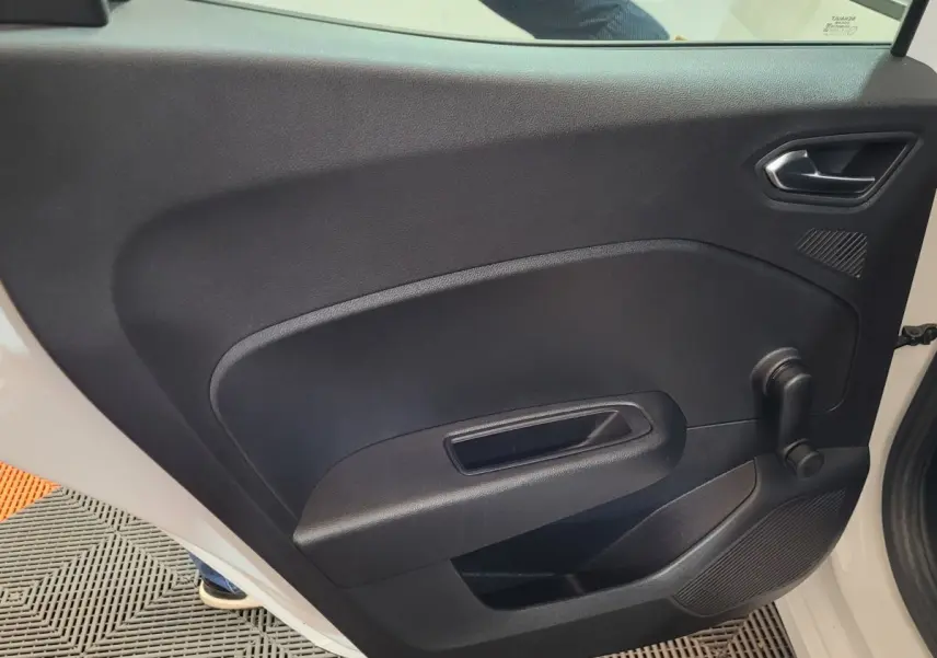 Vue intérieure côté gauche de la porte arrière noire d'une Renault Clio Business blanche avec manivelle de vitre.