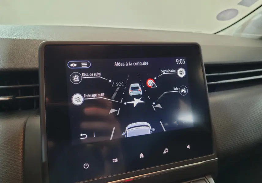 Écran tactile central montrant les aides à la conduite dans l'habitacle d'une Renault Clio Business blanche.